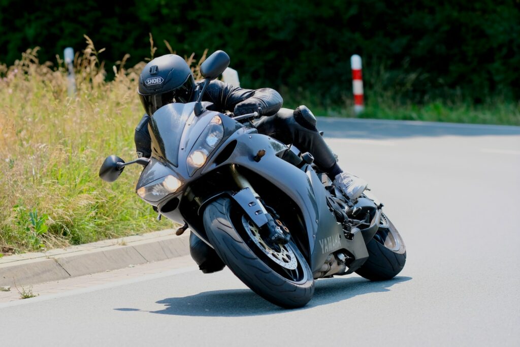 a man riding on the back of a motorcycle down a street